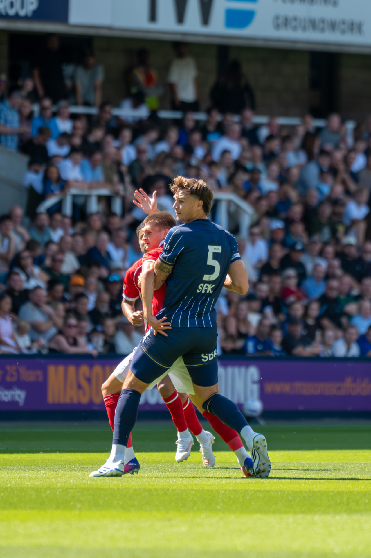 Defender holding off an opponent with an arm across