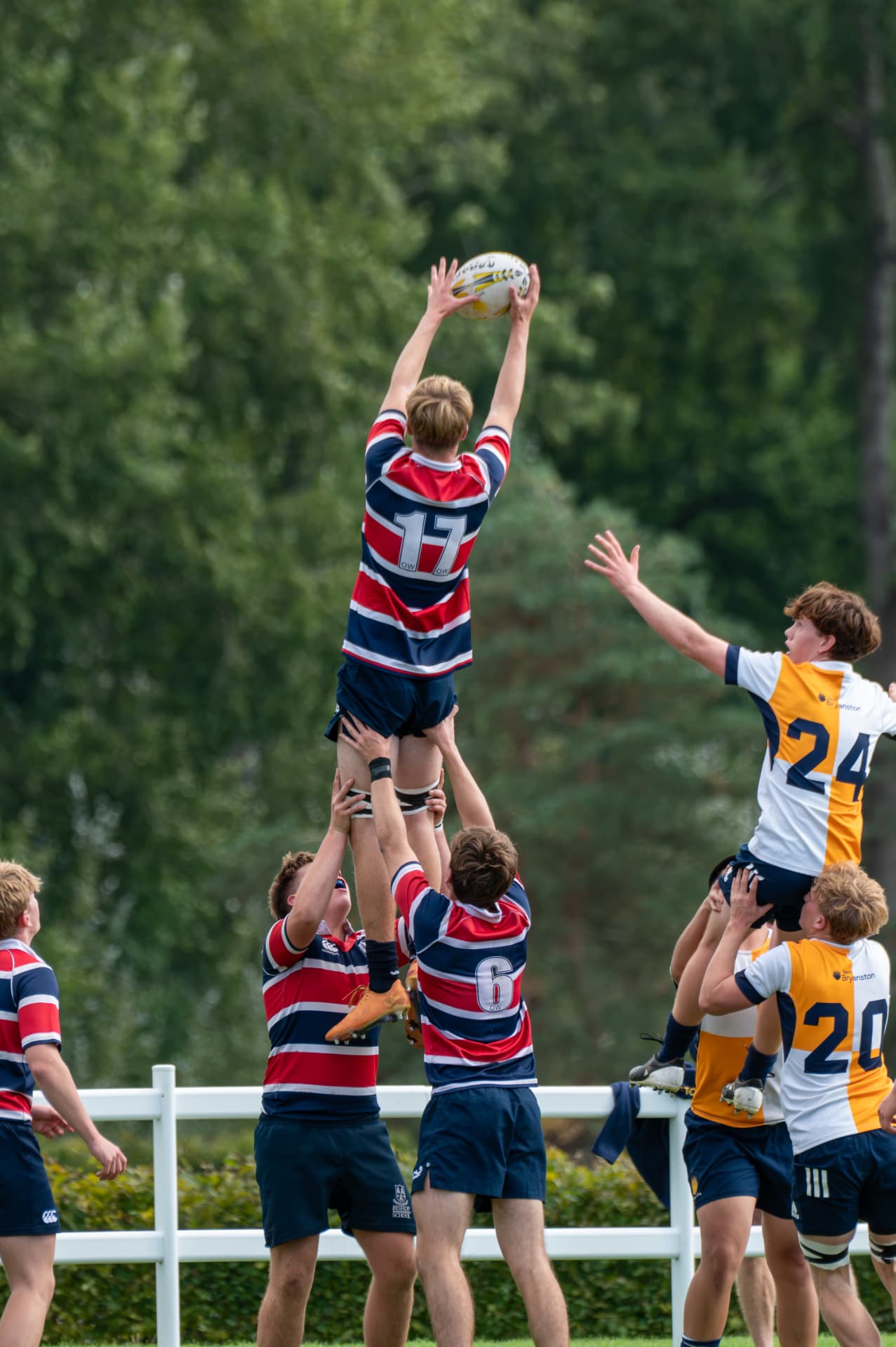 Rugby player lifted high to catch at a lineout