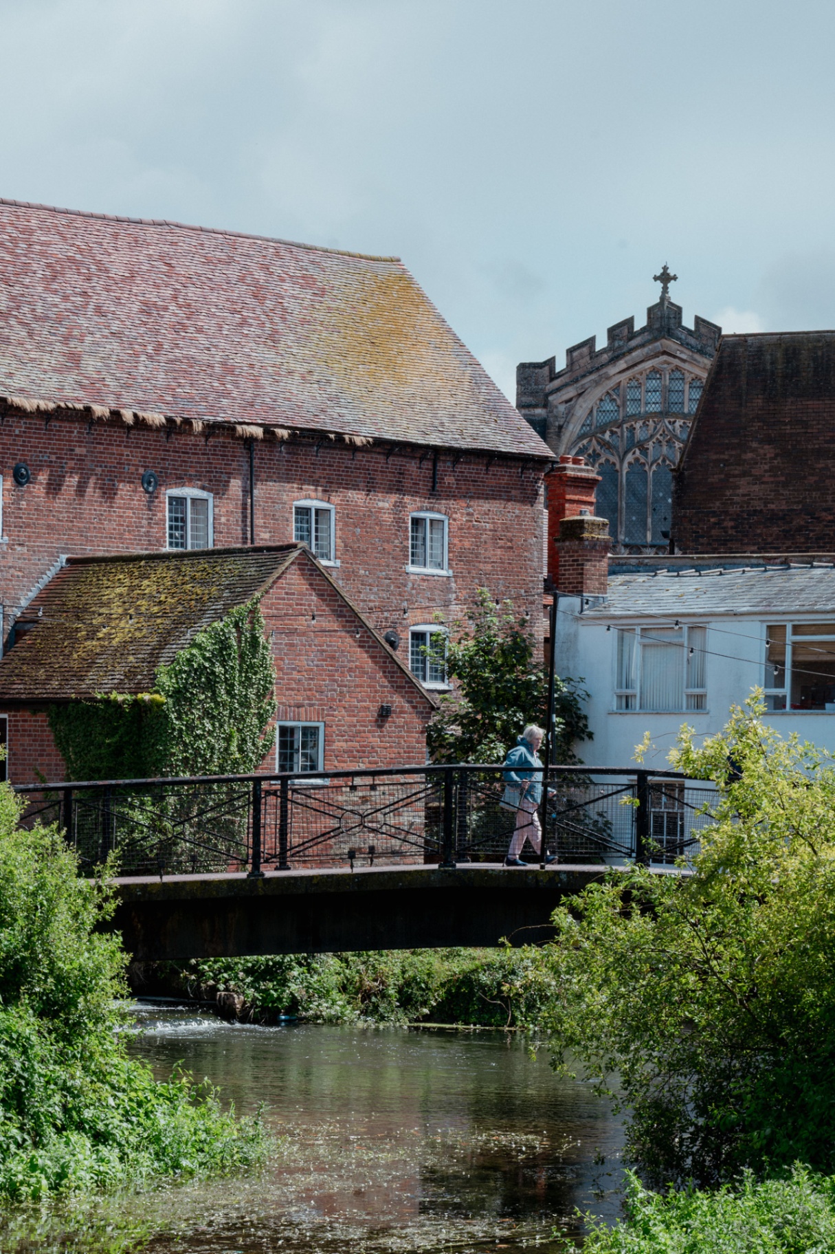 Person walking across a bridge over the river