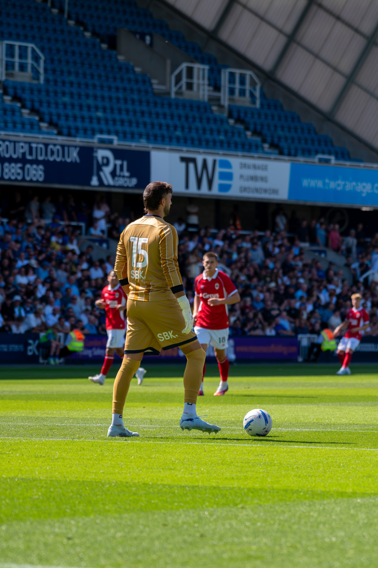 Goalkeeper in gold waiting on the ball at the edge of the box