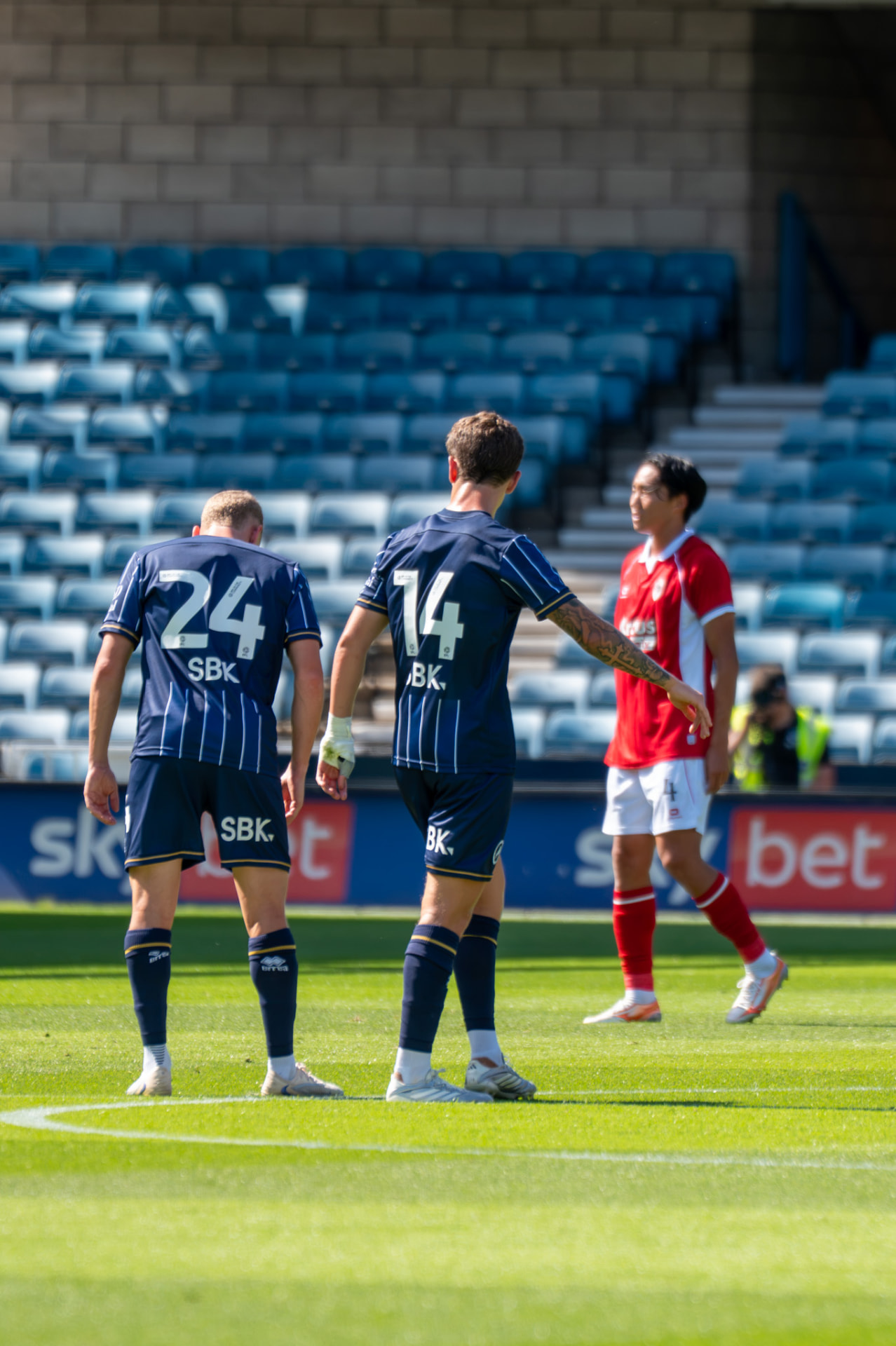 Two Millwall players walking together during a break in play
