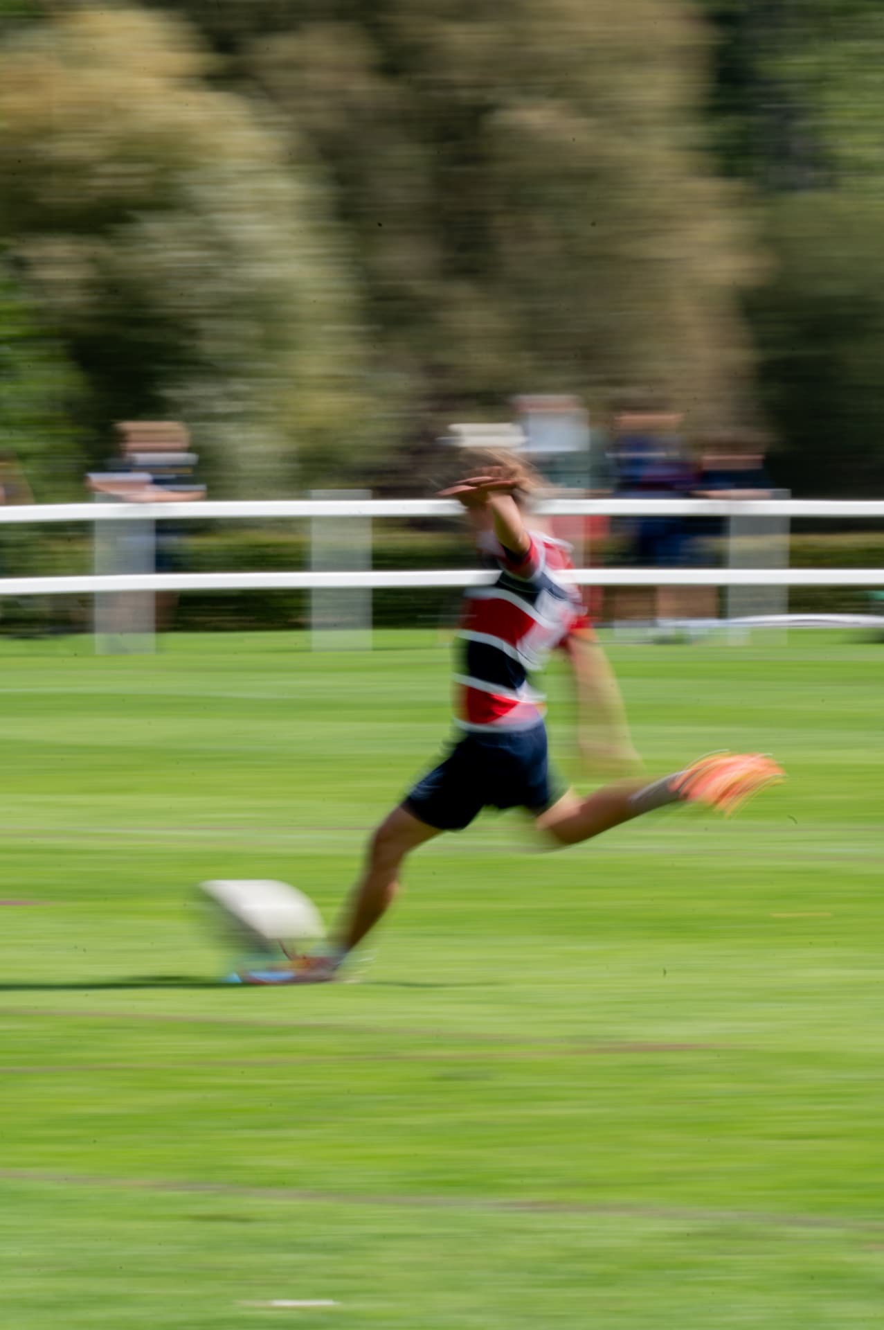 Rugby player striking the ball with motion blur