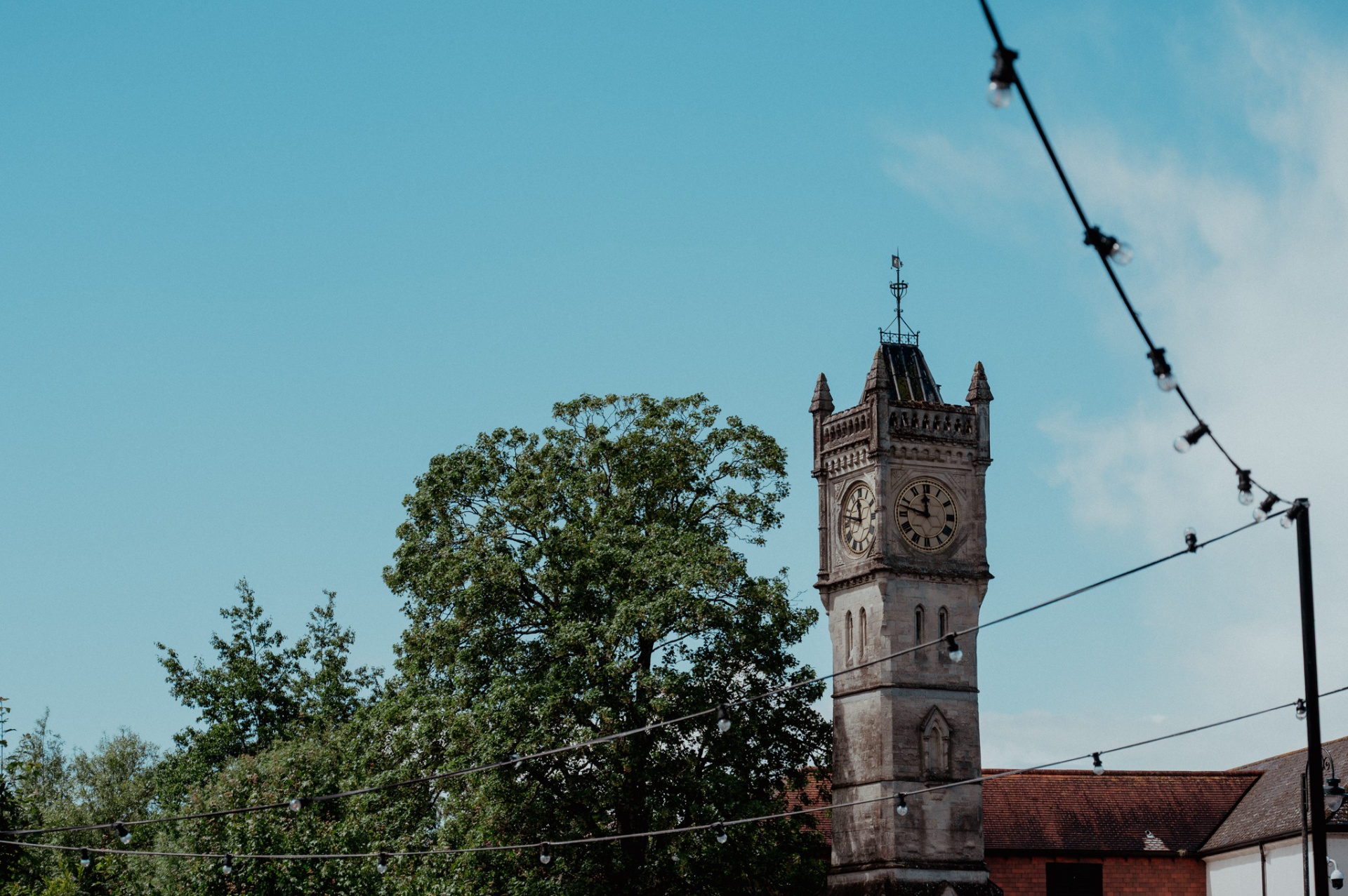 Clock tower with string lights and blue sky