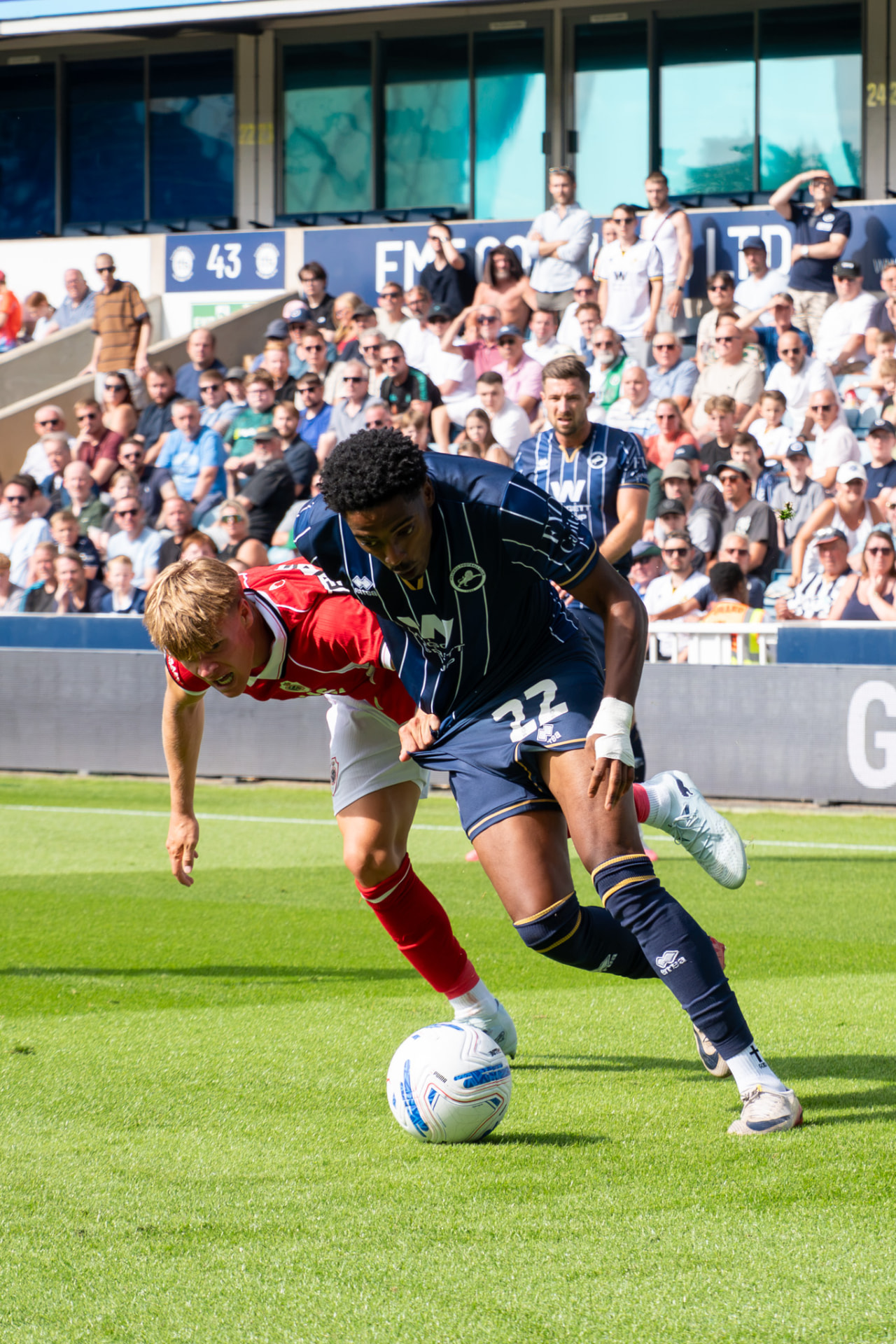 Millwall number 22 holding off a defender on the run