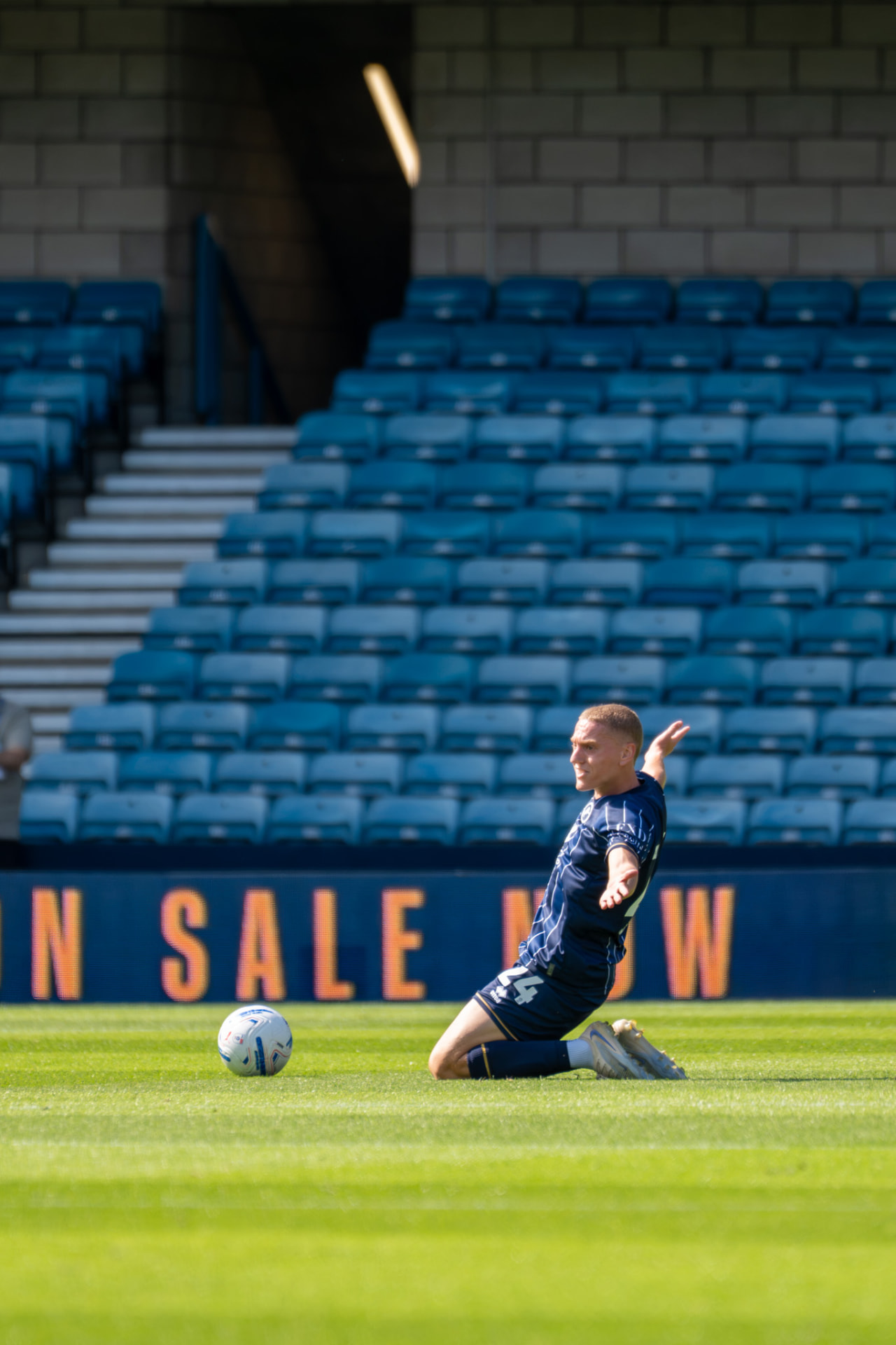 Millwall number 24 sliding across the turf