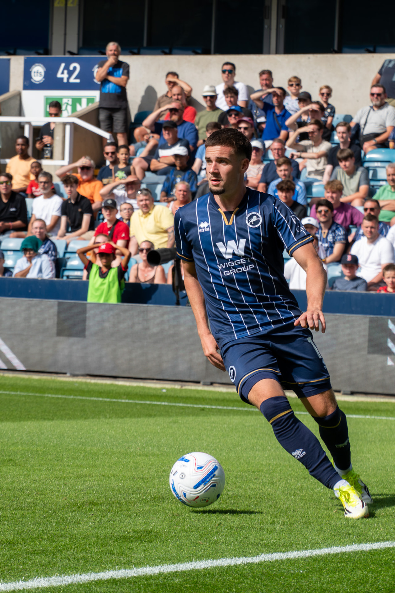 Millwall midfielder in possession in front of the crowd