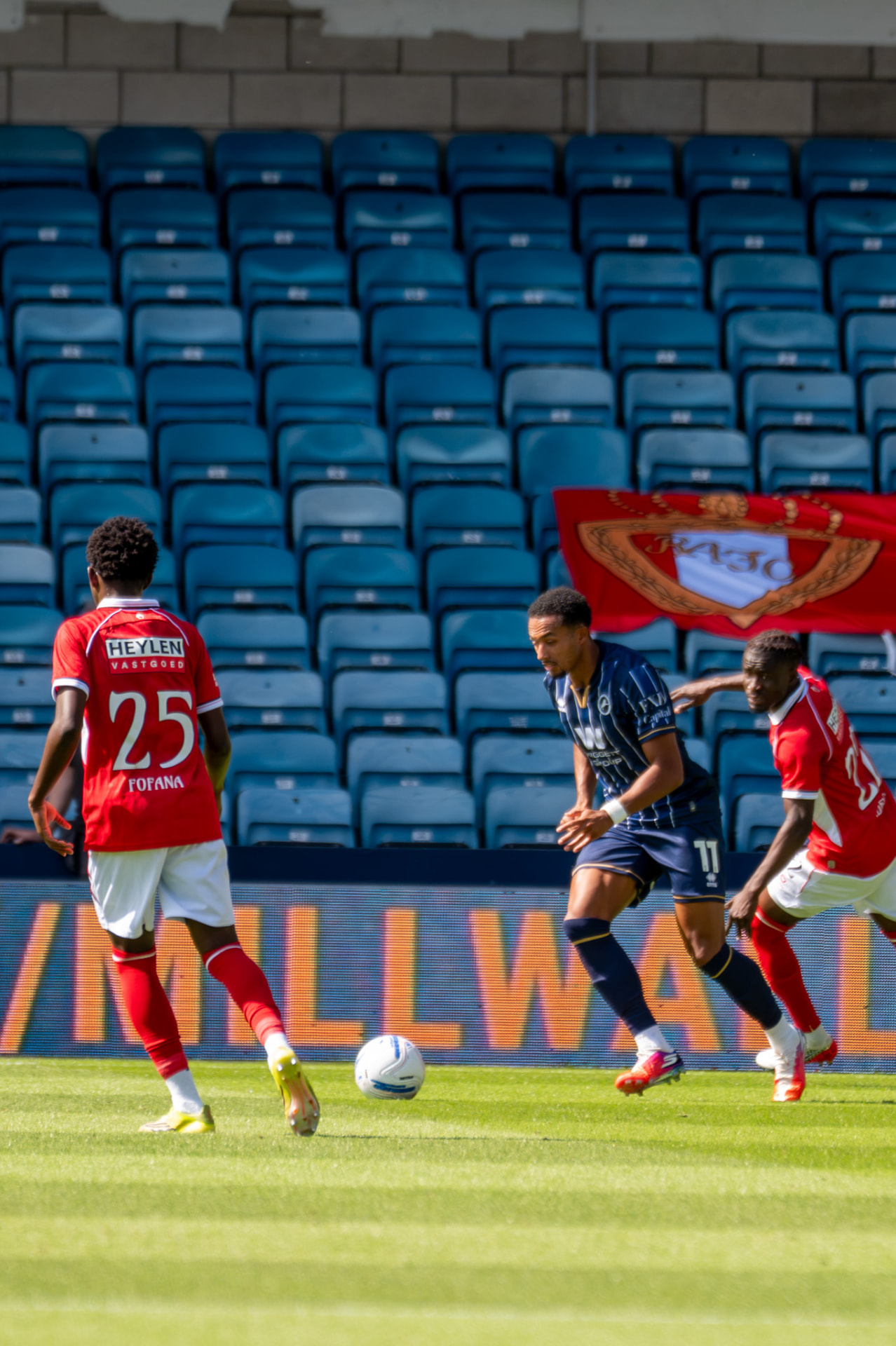 Millwall number 11 surrounded by two opponents