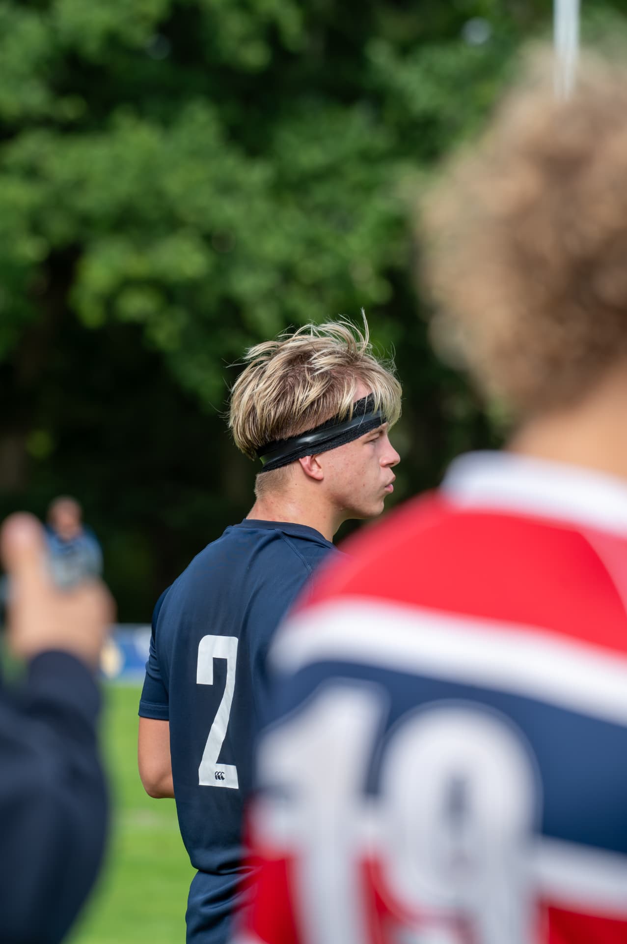 Rugby number seven watching play through foreground players
