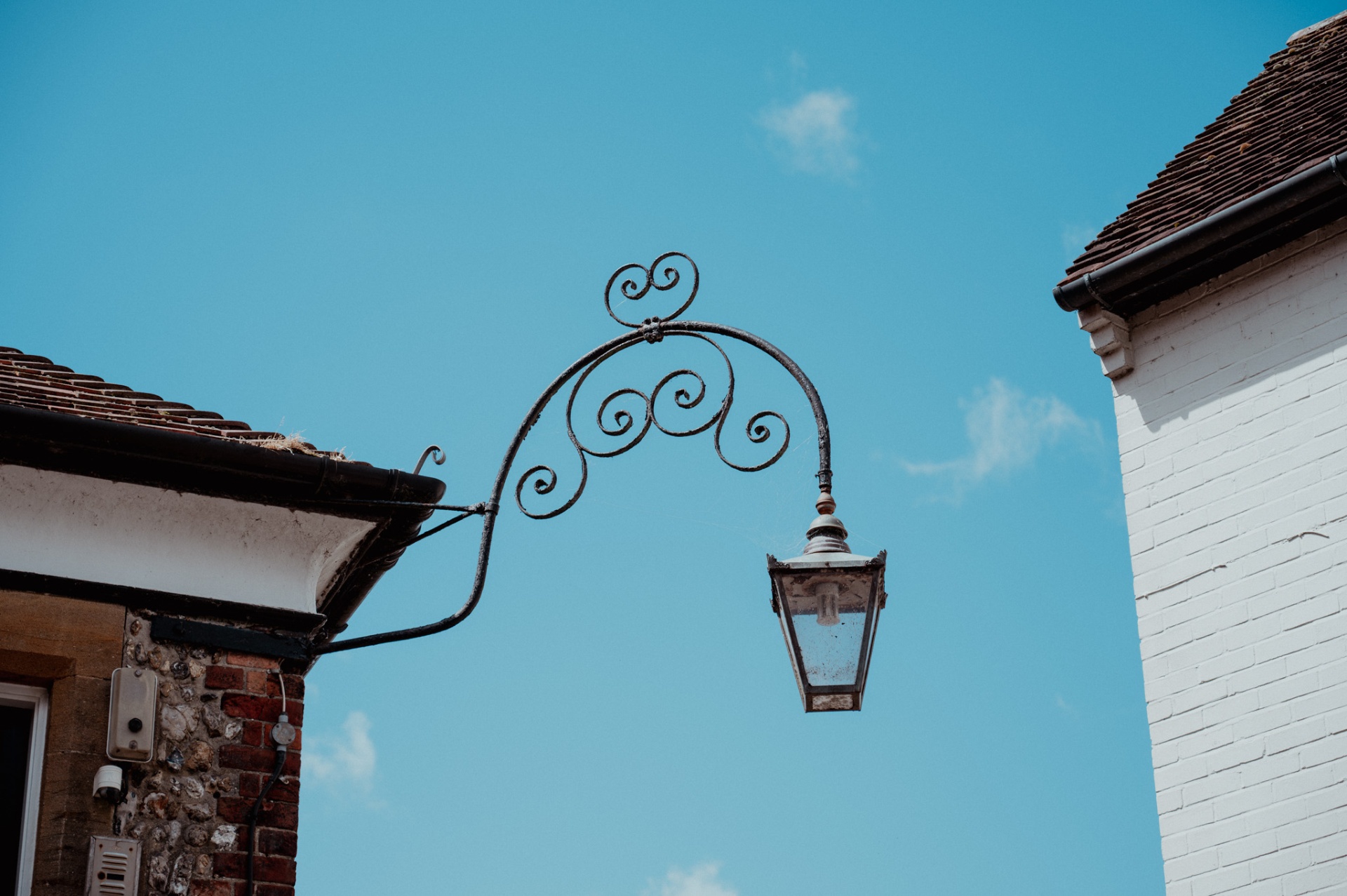 Decorative street lamp between two old buildings