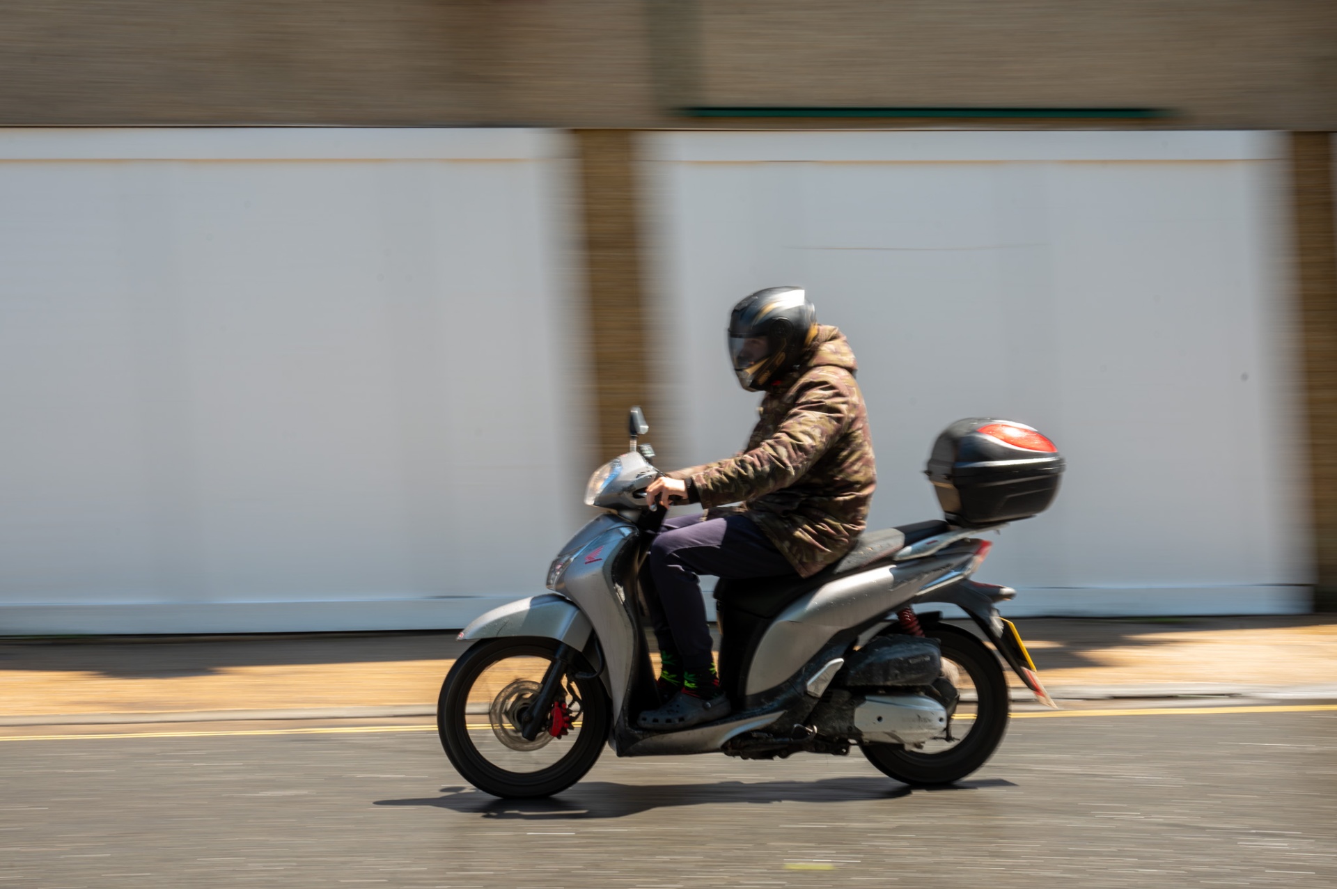 Scooter rider passing by in motion blur