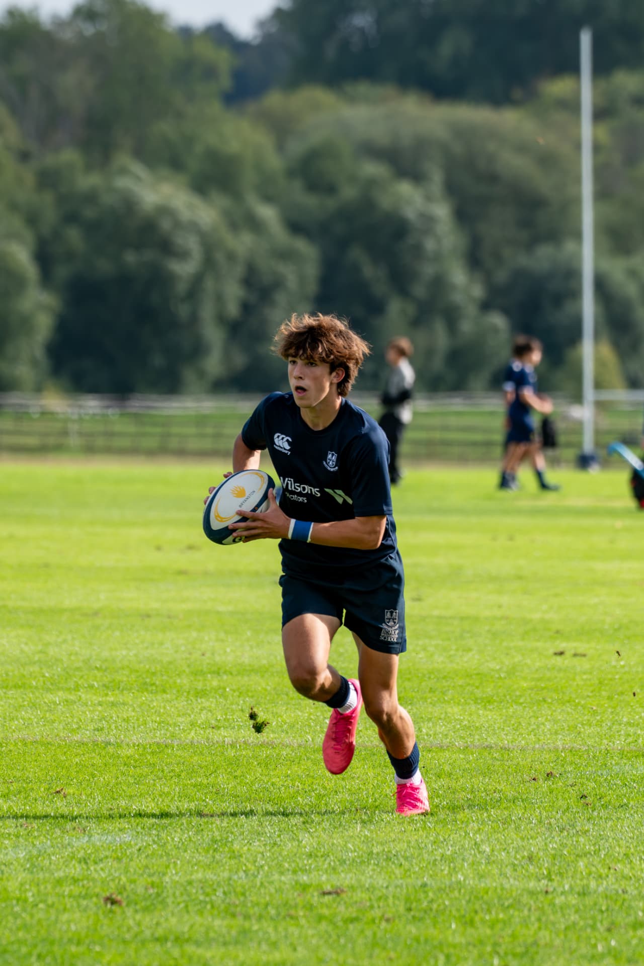 Rugby player running with the ball in open field