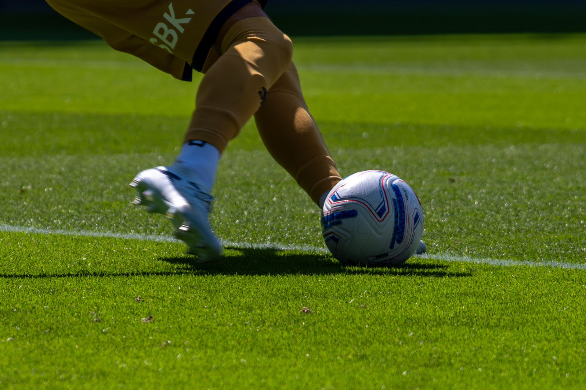 Close-up of a goalkeeper's boot striking the ball