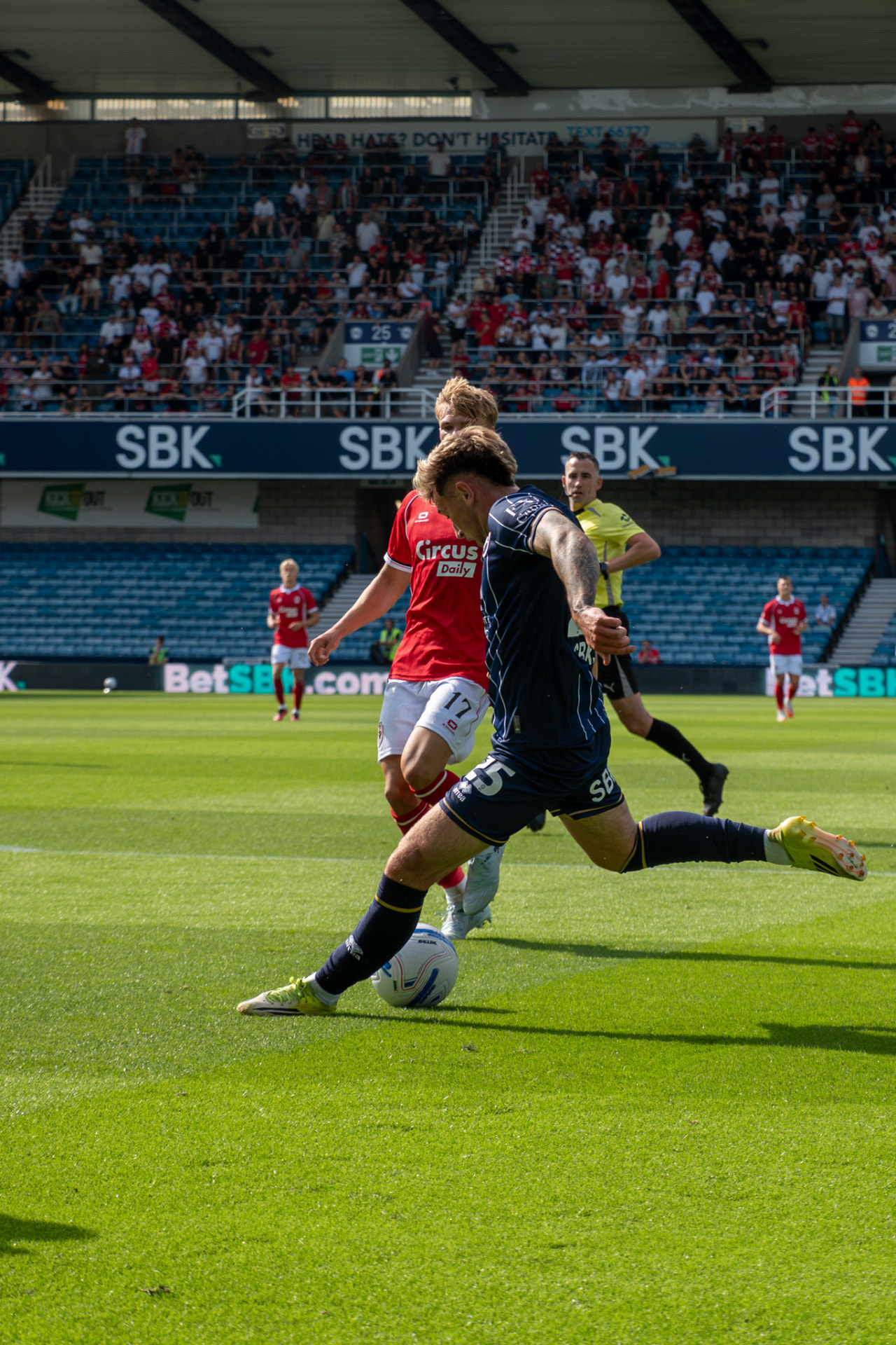 Millwall player swinging a cross in under pressure