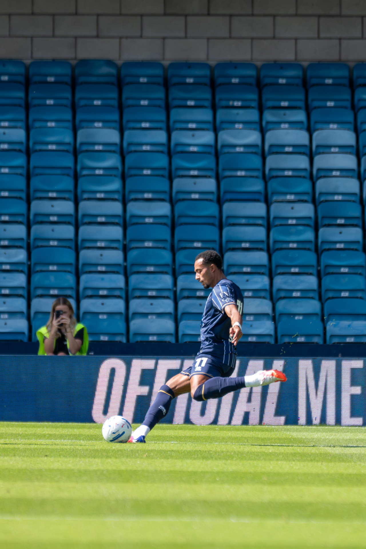 Player striking the ball in front of empty stands