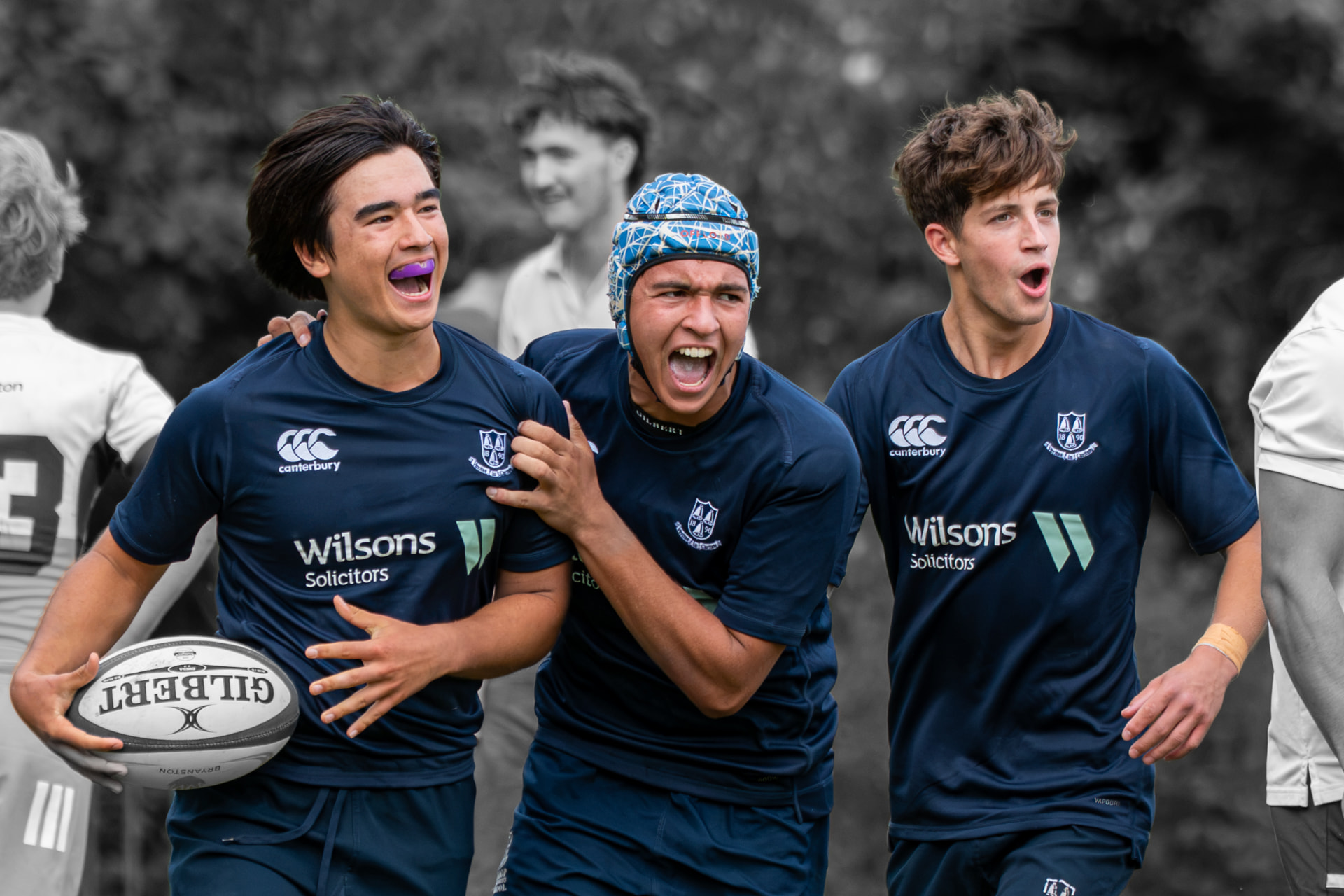 Rugby try scorer with teammates against a black-and-white background
