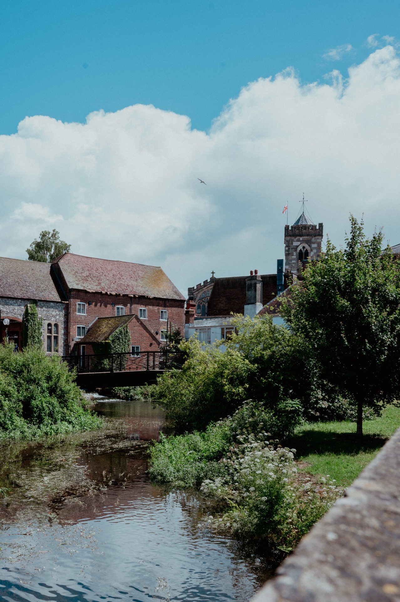 Riverside view with bridge, houses, and church tower