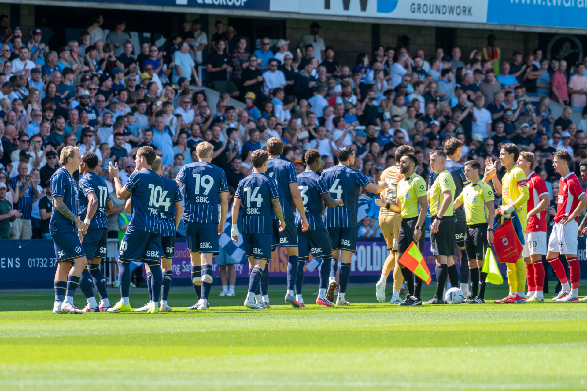 Players lining up and shaking hands before kick-off at The Den