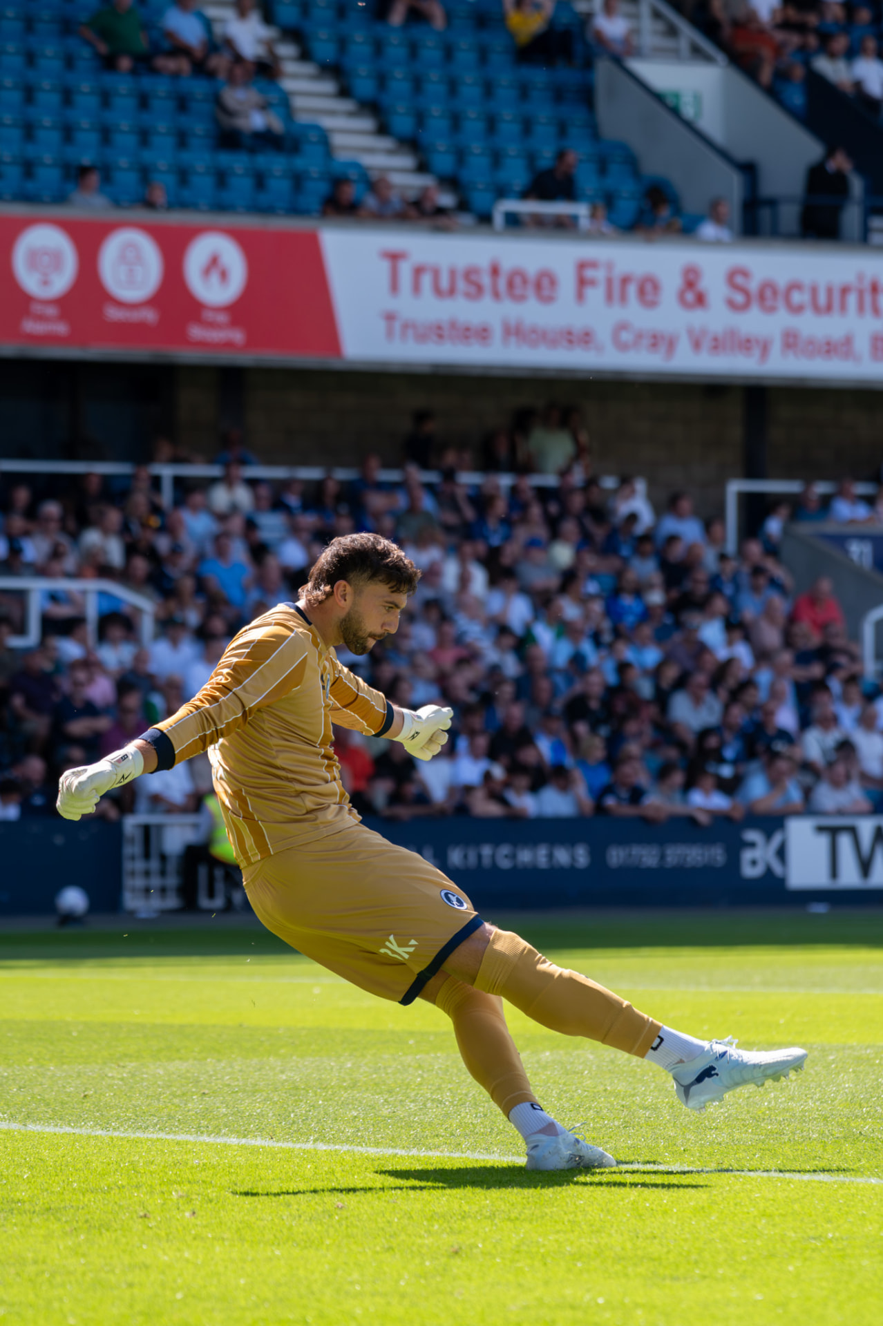 Goalkeeper striking the ball long in front of the crowd