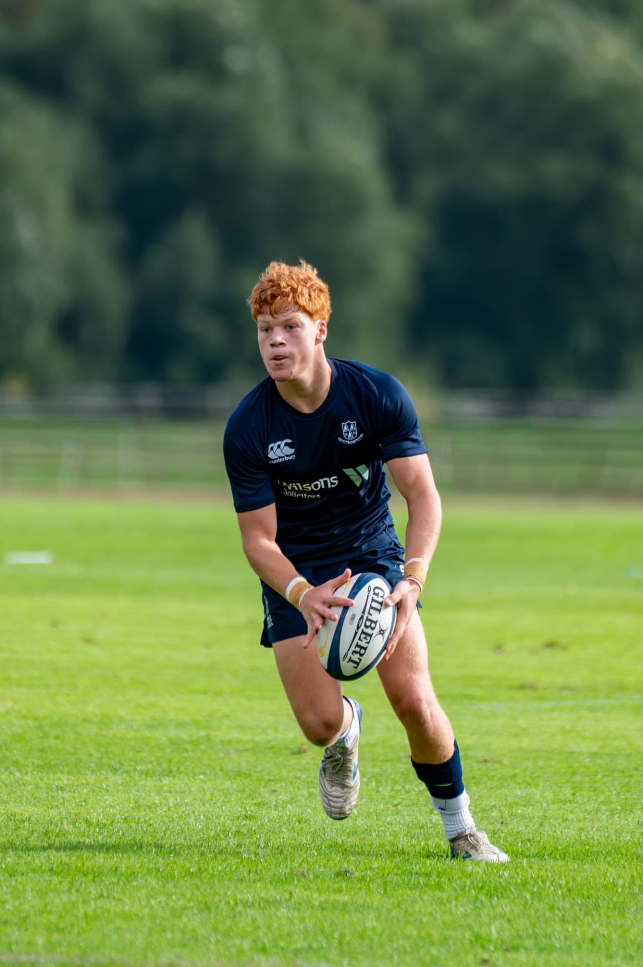 Rugby player running forward while preparing to pass