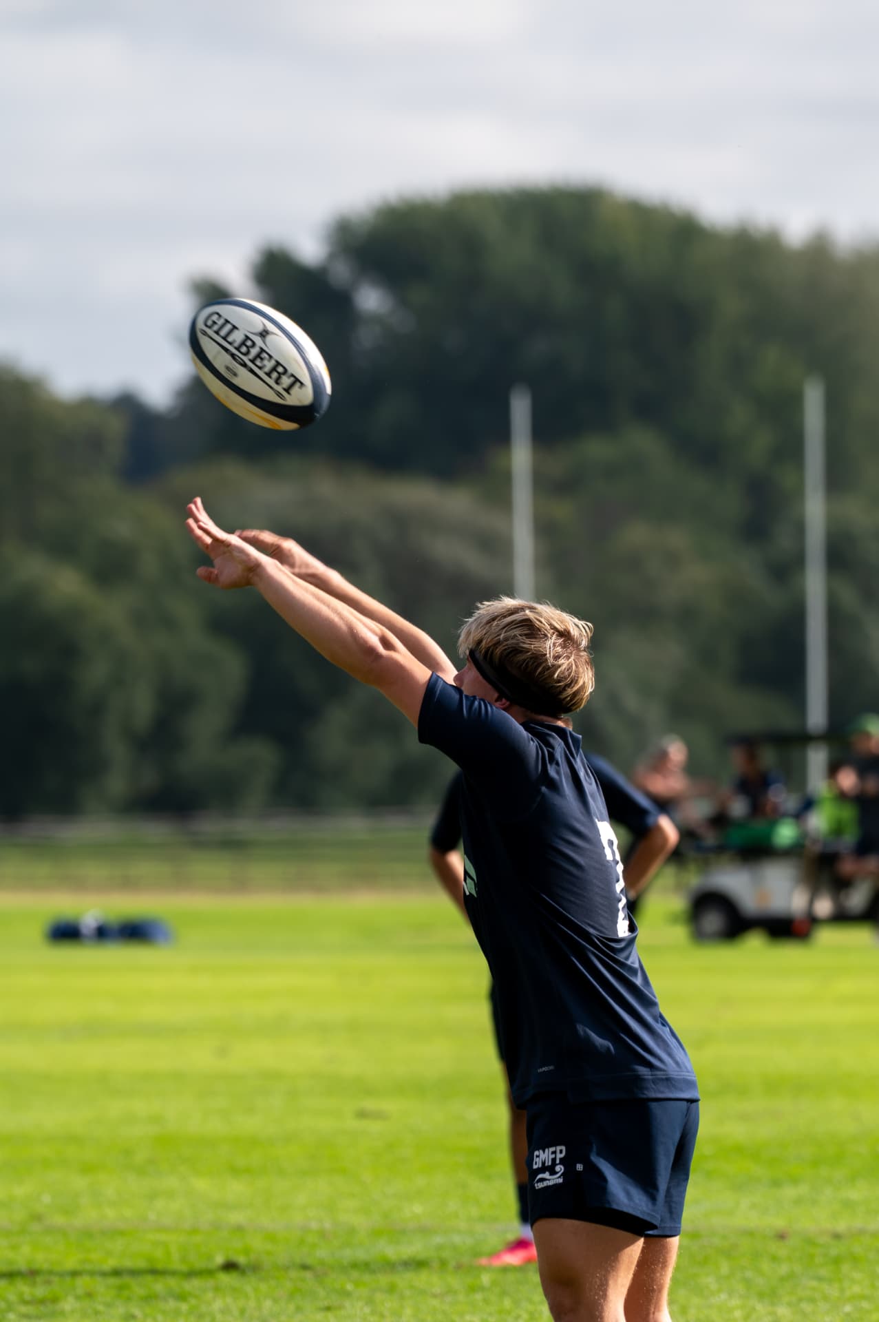 Rugby player passing the ball high across the field